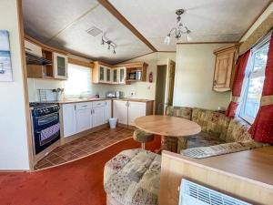 cocina con sofá y mesa en una habitación en Wonderful 8 Berth Caravan At Seawick Holiday Park In Clacton-on-sea Ref 27077r, en Clacton-on-Sea