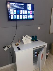 a white table with a tv on a wall at Katila-Rooms in Santa Maria