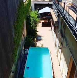 un objet bleu est assis entre deux bâtiments dans l'établissement Amelia's Home tra Etna e Taormina with pool, à Riposto