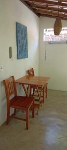 a wooden table and chairs in a room at Canto do Sabiá Caraíva in Caraíva +59 photos