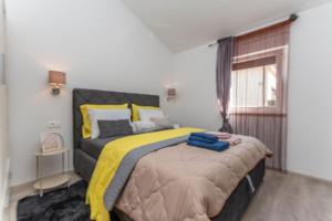 a bedroom with a large bed with a yellow blanket at Apartments Bella Vista in Nova Vas