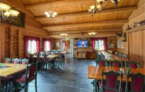 een eetkamer met tafels en stoelen en een televisie bij 2 Bedroom Awesome Home In Grue Finnskog in Svullrya