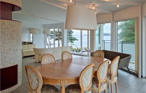 Beautiful Apartment In Mandal With House Sea View في ماندال: غرفة طعام مع طاولة وكراسي خشبية