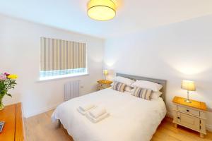 een slaapkamer met een wit bed en een raam bij Croyde Secret Garden in Croyde
