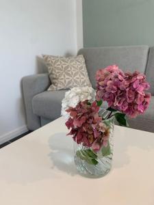 a vase filled with pink and white flowers on a table at Ferienwohnung Grüner Friese in Ihlow