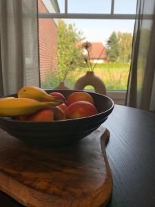 a bowl of fruit sitting on a wooden table at Ferienwohnung Grüner Friese in Ihlow
