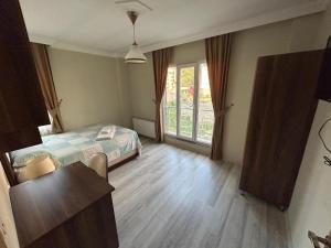 een slaapkamer met een bed en een groot raam bij Borahan Rezidans in Trabzon