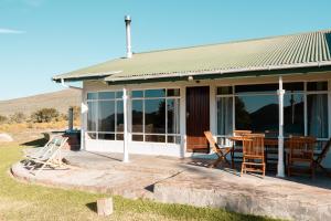 ein Haus mit Stühlen und einem Tisch auf einer Veranda in der Unterkunft Drie Kuilen Nature Reserve in Touwsrivier