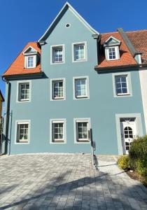 ein großes weißes Haus mit rotem Dach in der Unterkunft Ferienwohnung Winkler in Rothenburg ob der Tauber