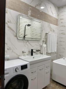 een badkamer met een wasmachine en een wastafel bij My Sweet Home In Rustavi sity 2 in Rustavi