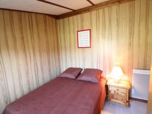 - une chambre avec un lit et une lampe sur une table de chevet dans l'établissement Gîte Arpajon-sur-Cère, 3 pièces, 4 personnes - FR-1-742-21, à Arpajon-sur-Cère