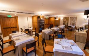a dining room with tables and chairs with white tablecloths at Papillo Hotels & Resorts Roma in Rome