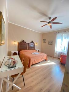 a bedroom with a bed and a table and a ceiling fan at Hotel Dali in Florence