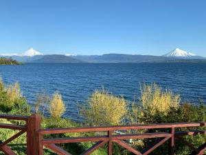 a view of a lake with snow capped mountains in the distance at Cabaña Familiar de Descanso y Paseo - Puyehue in Puyehue
