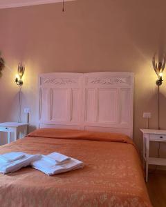 una camera da letto con un grande letto bianco con due asciugamani di Hotel Dali a Firenze