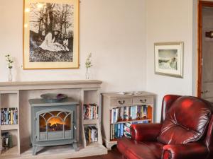 a living room with a leather chair and a fireplace at Highview in Keighley