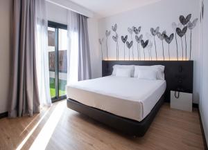 Postel nebo postele na pokoji v ubytování Sercotel Plana Suites + 23 fotografií