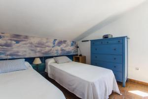 ein Schlafzimmer mit 2 Betten und einer blauen Kommode in der Unterkunft Villas Florida in Conil de la Frontera