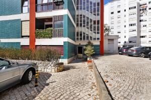 un coche aparcado delante de un edificio en Quiet Under The Trees, en Estoril