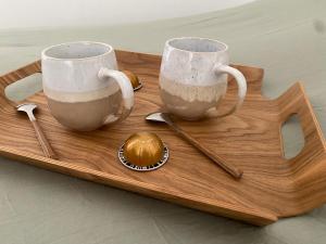 dos tazas de café en una bandeja de madera con cucharas en Appartement cocooning l'ESCALE 2POST9 en Espira-de-lʼAgly