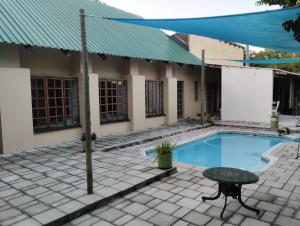 uma casa com uma piscina e uma mesa e um edifício em Kosi Moon Bed and Breakfast em Manguzi