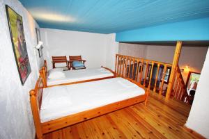 1 dormitorio con 1 cama y suelo de madera en Foinikas Rooms, en Erateini