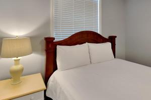 a bedroom with a bed and a table with a lamp at The Village #514 in Blue Mountain Beach