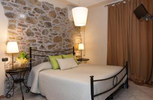 a bedroom with a bed and a stone wall at Hotel Monti in Lamporecchio