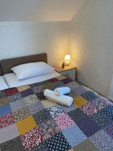a bedroom with a bed with two towels on it at Medve Barlang üdülőházak in Pilisszentkereszt