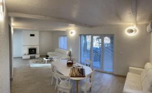 a living room with a white table and chairs at Medve Barlang üdülőházak in Pilisszentkereszt