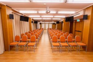 an empty hall with orange chairs in a room at Papillo Hotels & Resorts Roma in Rome