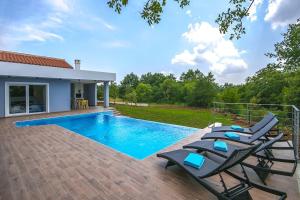 Una piscina con tumbonas al lado de una casa. en Villa Sicutti by IstriaLux, en Šivati