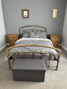 a bed with a foot board and a ottoman in a bedroom at Idyllic Retreat in Dalton-In-Furness Sleeps 3! in Dalton in Furness