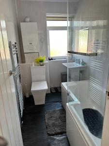 een badkamer met een wastafel, een toilet en een raam bij Idyllic Retreat in Dalton-In-Furness Sleeps 3! in Dalton in Furness