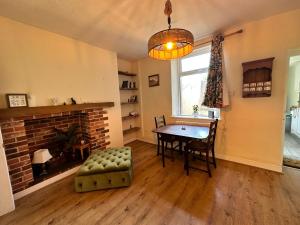 een eetkamer met een tafel en een open haard bij Idyllic Retreat in Dalton-In-Furness Sleeps 3! in Dalton in Furness