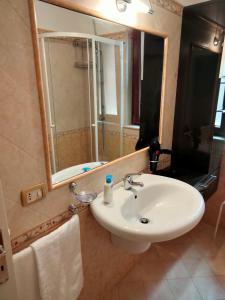 y baño con lavabo blanco y espejo. en La Castellina 23, en Sulmona