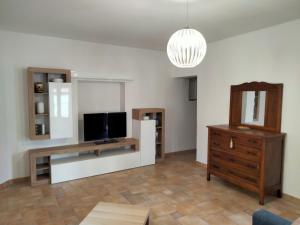 a living room with a tv and a wooden dresser at La Castellina 23 in Sulmona