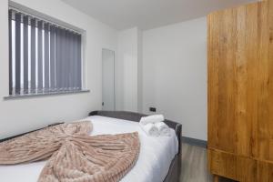 um quarto com uma cama com um cobertor em Charles Alexander Short Stay - The Banks Apartments em Blackpool