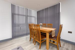 - une salle à manger avec une table et des chaises en bois dans l'établissement Charles Alexander Short Stay - The Banks Apartments, à Blackpool