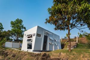 una casa modulare su una collina con un albero di Twist, Tiny home on the Cliff a Lavasa