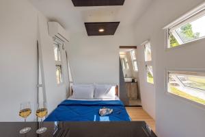 una piccola camera con letto blu in una stanza con finestre di Twist, Tiny home on the Cliff a Lavasa