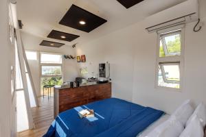 un soggiorno con una coperta blu su un divano di Twist, Tiny home on the Cliff a Lavasa