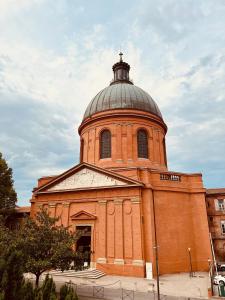 a large brick building with a dome on top of it at Duplex Tolosa - Pont-Neuf, Dôme de la Grave, 2 BDRs 85m2, AC, Free private car park 200m away - T3 85m2 avec clim, parking couvert gratuit à 200m in Toulouse