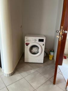 una lavadora en un rincón de una habitación en Vee's place, en Buwate
