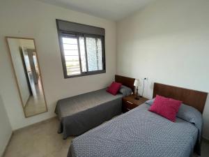 Zimmer mit 2 Betten, einem Spiegel und einem Fenster in der Unterkunft Kione Torresblancas in Torrenostra