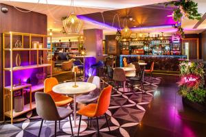 un restaurant avec des tables et des chaises colorées et un bar dans l'établissement Mercure London Bridge, à Londres