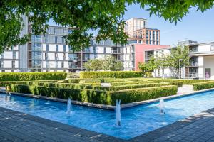 a hedge garden with buildings in the background at Cotels at Vizion Serviced Apartments, Superfast Broadband, Central Location, Free Parking, Fully Equipped Kitchen in Milton Keynes