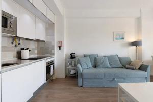 sala de estar con sofá azul en la cocina en Sea View Estoril, en Estoril