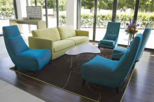 a living room with a couch and blue chairs at Grimm's Potsdamer Platz in Berlin