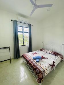 a bedroom with a bed with a blue teddy bear on it at Homestay CikguMa - Netflix & Wifi in Kota Bharu